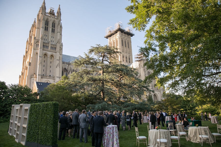event goers in formalwear mill about the lawn in front of the National Cathedral