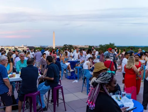 attendees gather on a rooftop overlooking the Washington Monument