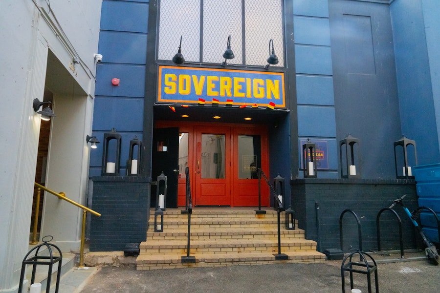 exterior of the sovereign: bright red double doors and a few steps with a blue facade