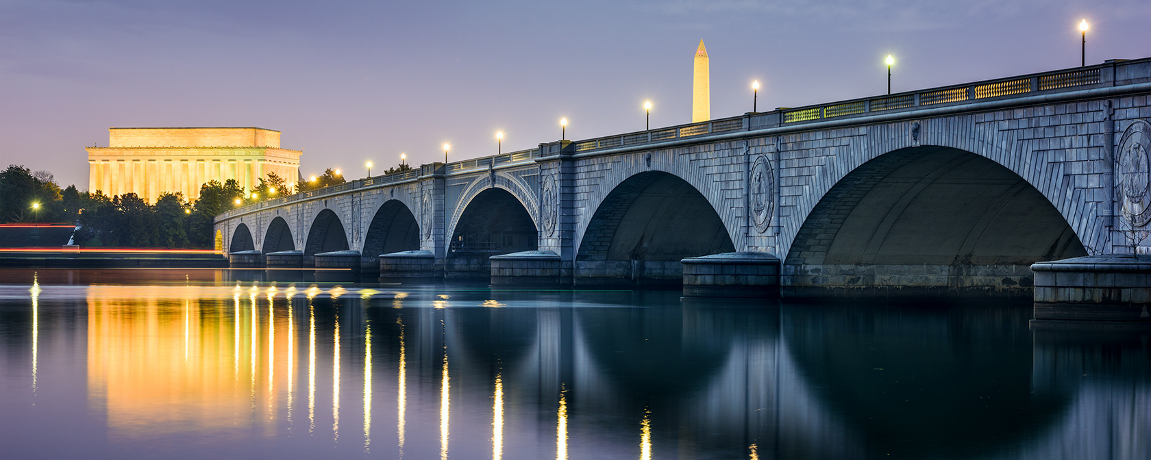 Le pont d'Arlington illuminé la nuit avec DC Skyline avec Lincoln Memorial et Washington Monument