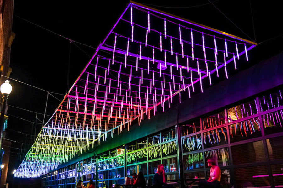 Installation lumineuse arc-en-ciel suspendue entre des bâtiments à Georgetown