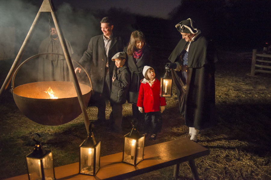 Familia alrededor de un fuego durante Mount Vernon a la luz de las velas