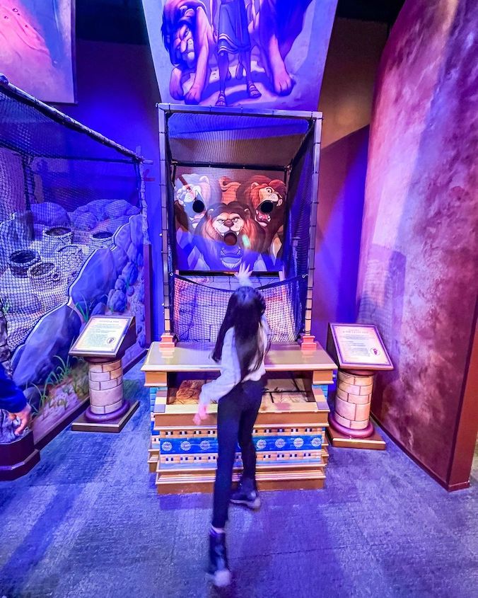 Child playing a Museum of the Bible-themed arcade game