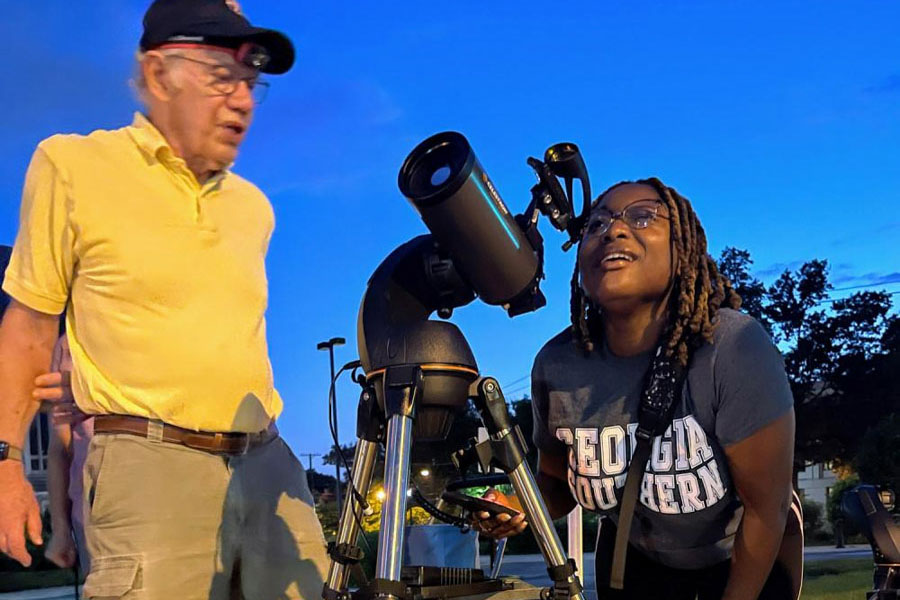 Una persona che guarda attraverso un telescopio mentre osserva le stelle