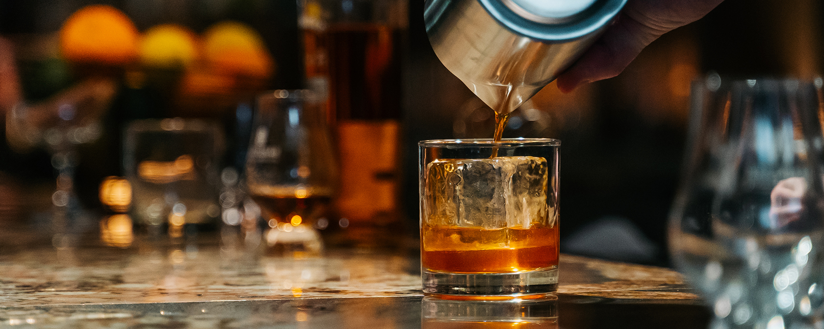 Barman versant du whisky dans un verre