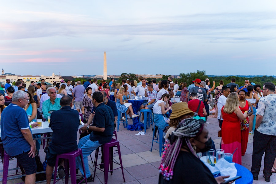 Die Teilnehmer versammeln sich auf einem Dach mit Blick auf das Washington Monument