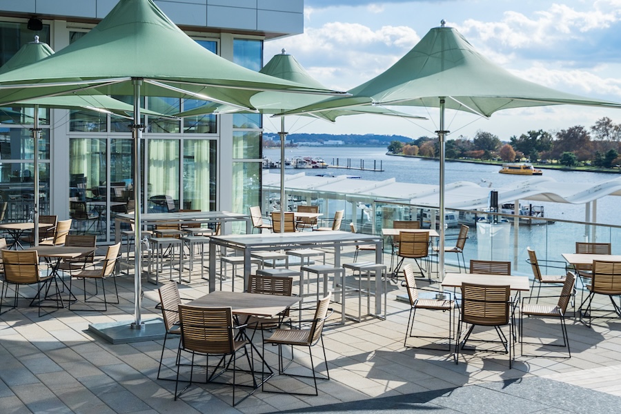 patio seating with umbrellas and tables overlooking the water at the Wharf