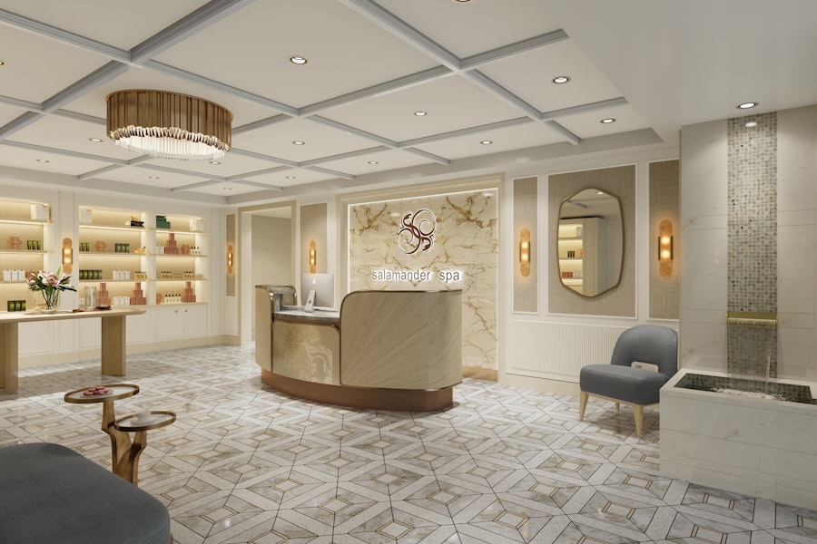 A luxurious spa reception area with elegant, light-colored decor. The reception desk is made of marble, with shelves displaying various beauty products. The room is well-lit with chandeliers and soft lighting.