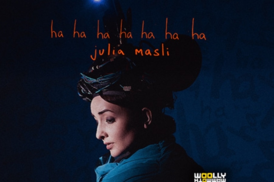A theater poster for a performance by Julia Masli. The poster features Julia Masli in profile with an elaborate headpiece against a dark blue background. The text 'ha ha ha ha ha ha ha' and 'Julia Masli' are written in orange.