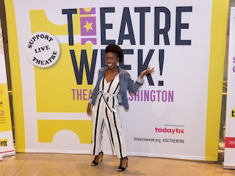 Woman posing in front of a Theatre Week banner.