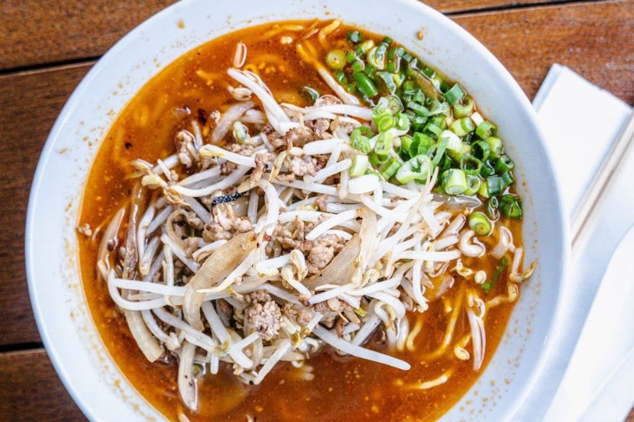 Close-up of Spicy Shoyu Ramen at Haikan with red broth, garnished with bean sprouts and scallions