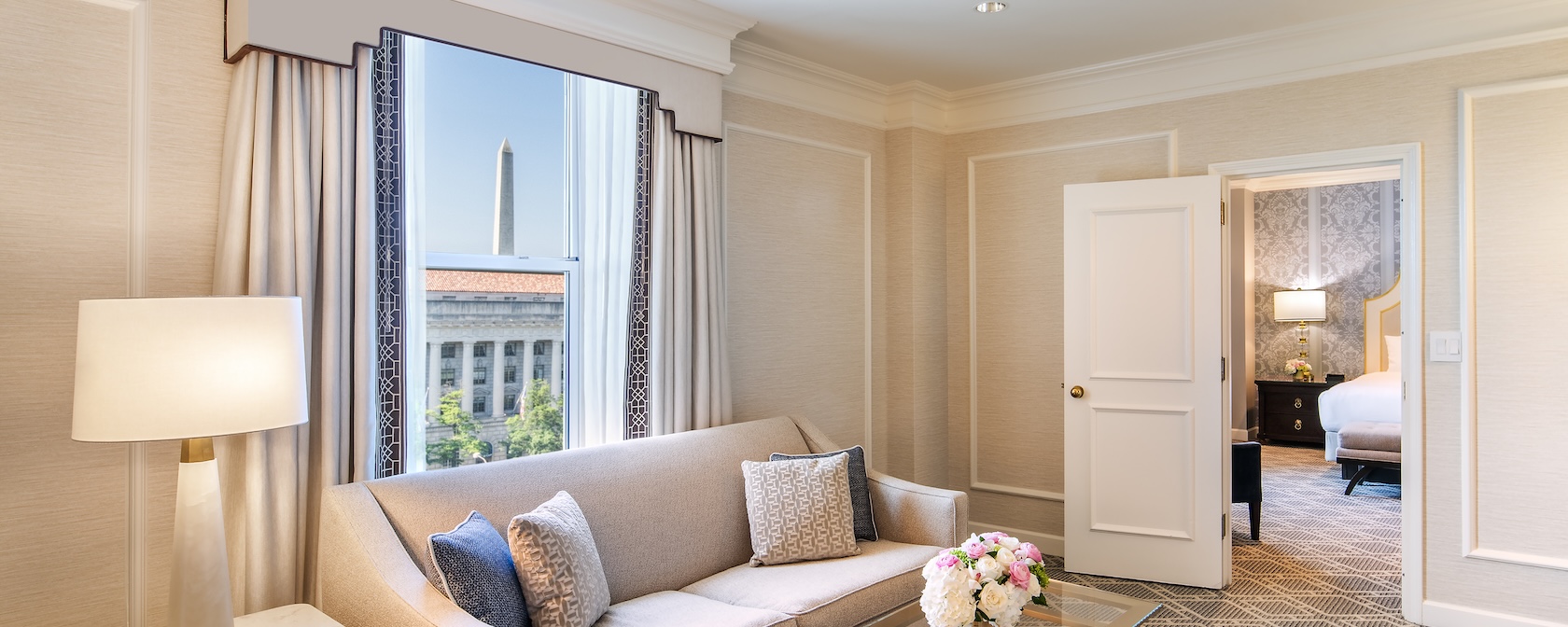 An elegant hotel room with a view of the Washington Monument. 