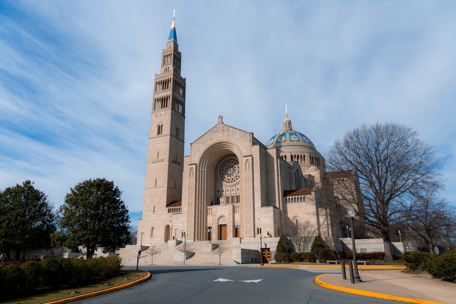 The Basilica of the National Shrine of the Immaculate Conception with a blue sky behind it.