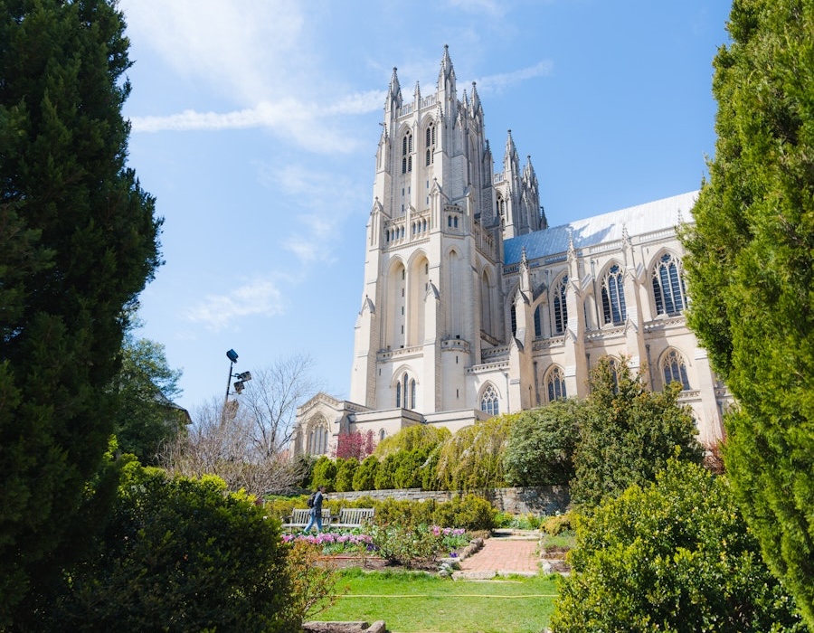 The towers of Washington National Cathedral rise above lush gardens on a bright spring day.