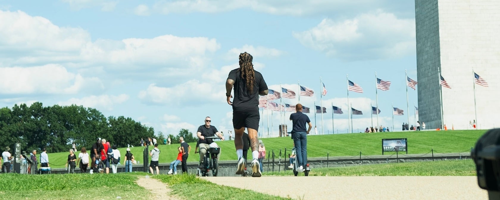A man runs along the National Mall near the Washington Monument on a sunny day. 