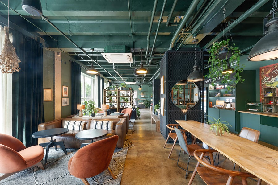 Modern lounge area at Hotel Nell in Washington, DC featuring green tones, wood furnishings, plants and cozy seating in the Union Market District