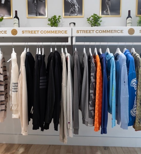Clothing store rack with sweaters and jackets in neutral and blue tones
