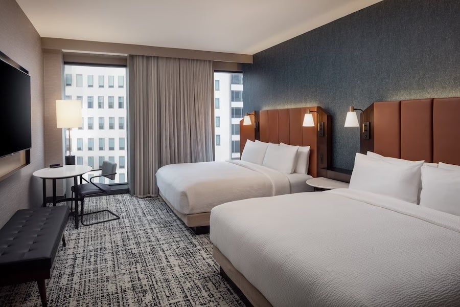 Tempo by Hilton Washington DC hotel room with two queen beds, desk, and city view through window
