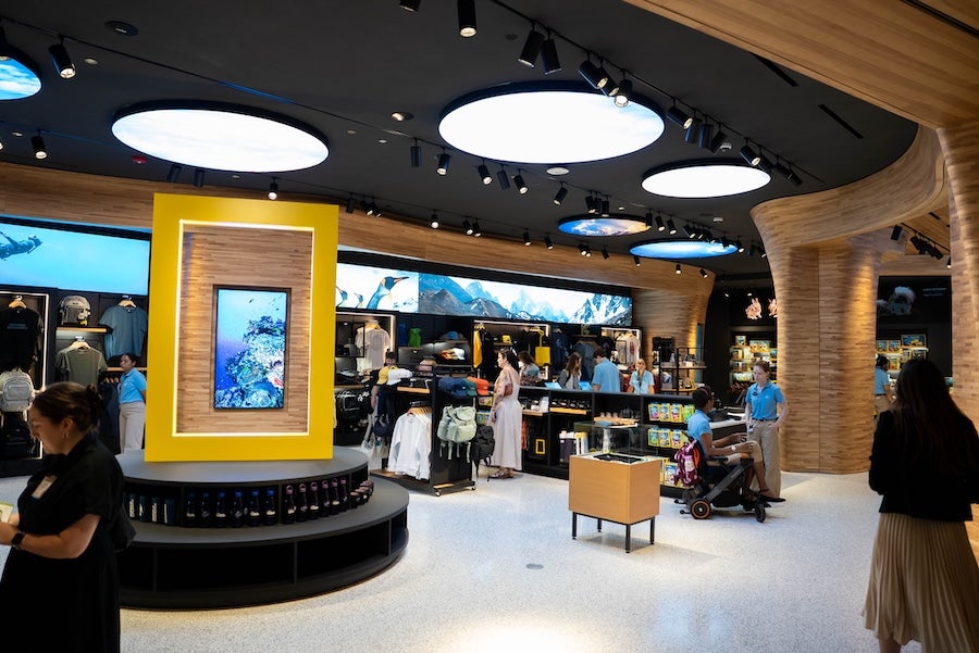 Modern retail store interior with round ceiling lights and shoppers browsing displays