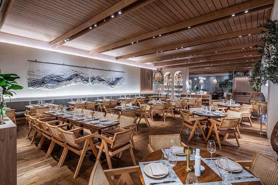 Modern restaurant with wooden tables, chairs and warm lighting