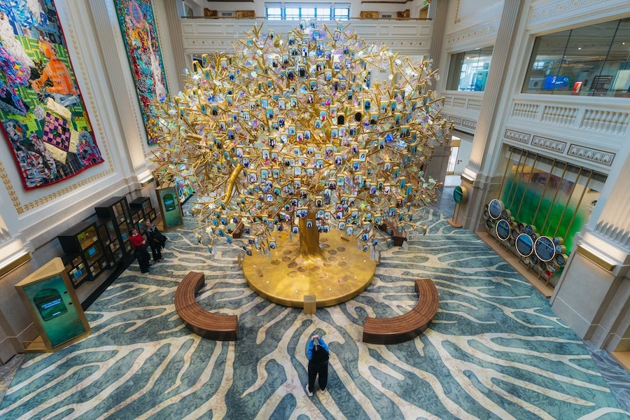 Milken Center lobby interior with large golden tree sculpture, viewed from above