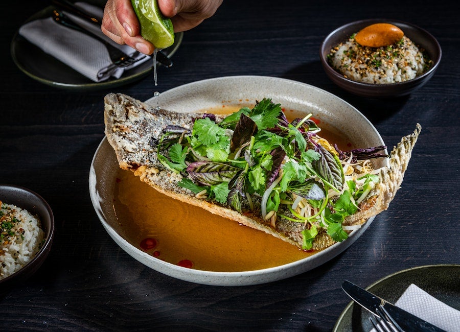 Fish topped with greens and sauce 