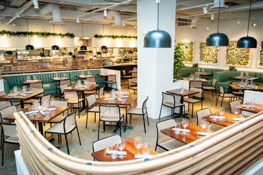 Restaurant dining area with wooden tables, chairs and hanging pendant lights