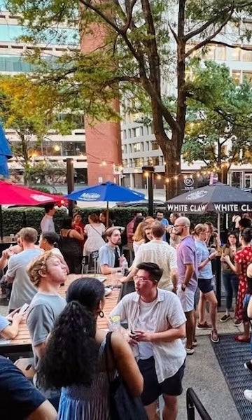 Crowded outdoor bar on a tree-lined street