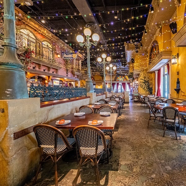 Outdoor restaurant patio at night with string lights and empty tables, warm glow