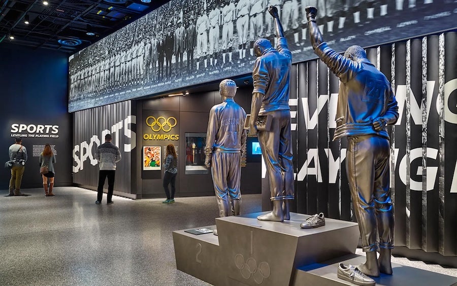 Statues of athletes on a pedestal in a sports exhibit hall