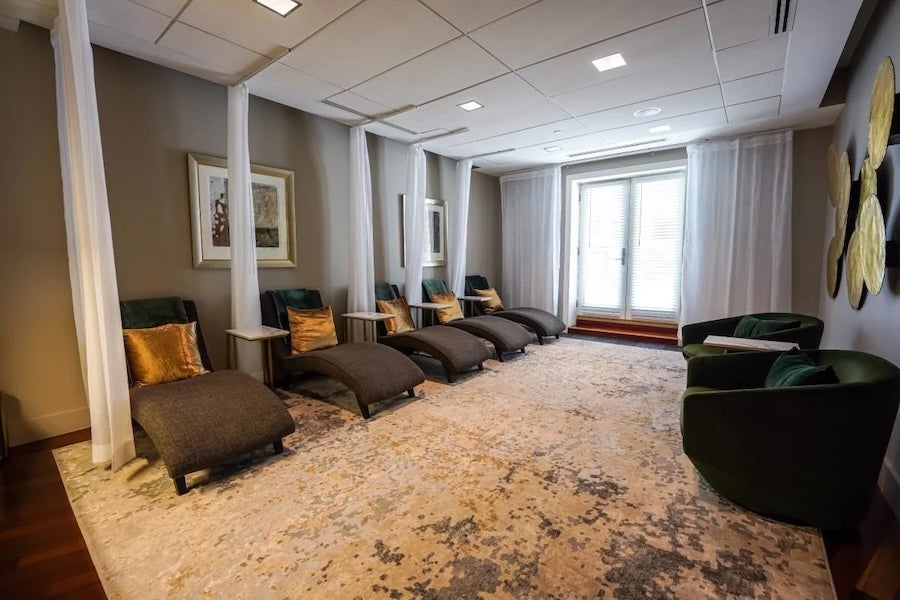 Spa lounge with reclining chairs, wall art and soft daylight through curtains