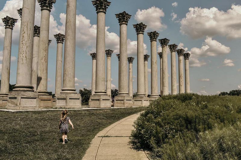 @ auroraphoto.co - Niño frente a las columnas del Capitolio Nacional en el Arboreto de los Estados Unidos - Museo gratuito al aire libre en Washington, DC