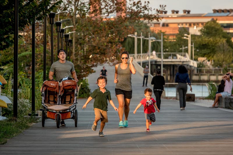 Famiglia che corre lungo Anacostia Riverwalk Trail - Esercizio all'aperto e sentieri a Washington, DC