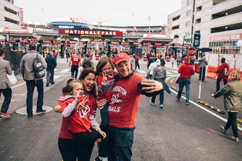 Family taking selfie in front of Nationals Park before Washington Nationals baseball game in Washington, DC