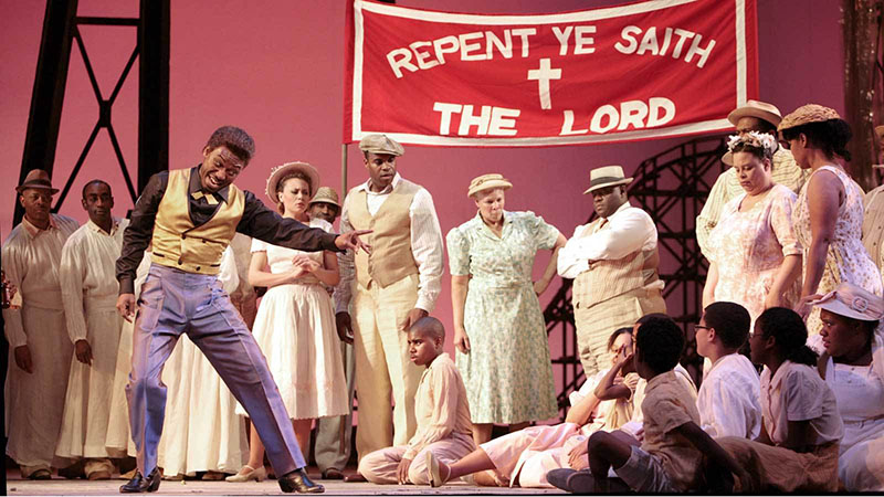 Cast of Porgy and Bess acting out in a church scene on stage