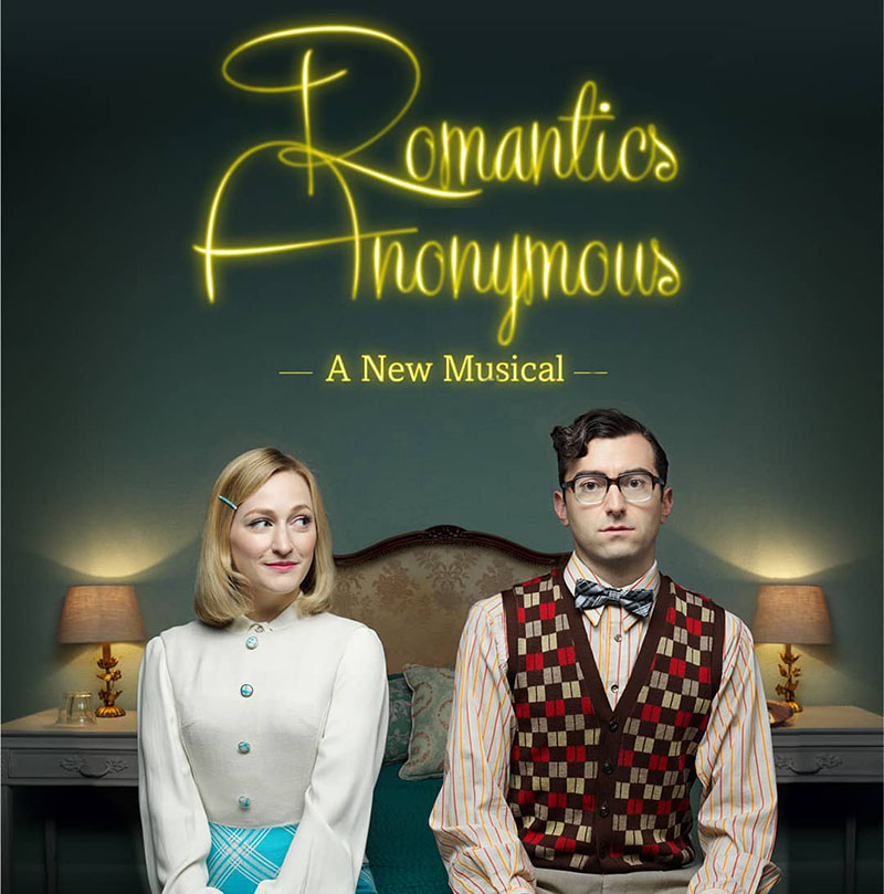 Two actors from play Romantics Anonymous Musical on bed
