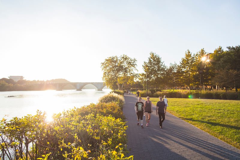 Pessoas caminhando ao longo do Georgetown Waterfront Park em uma tarde ensolarada em Washington, DC