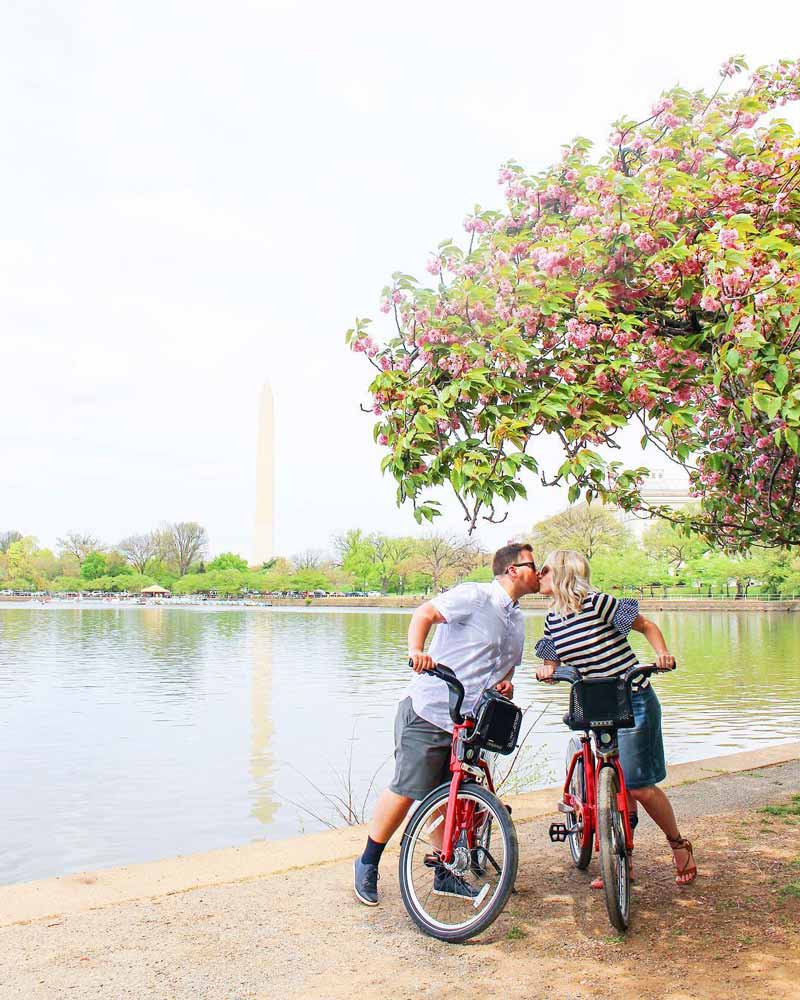 @the.snyder.spot - Mari et femme s'embrassant à vélo devant le Tidal Basin - Endroits romantiques à visiter à Washington, DC