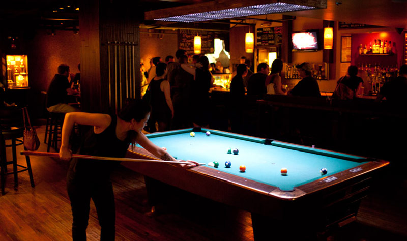 Woman playing billiards at breadsoda - Bars and restaurants where you can play ping pong in Washington, DC