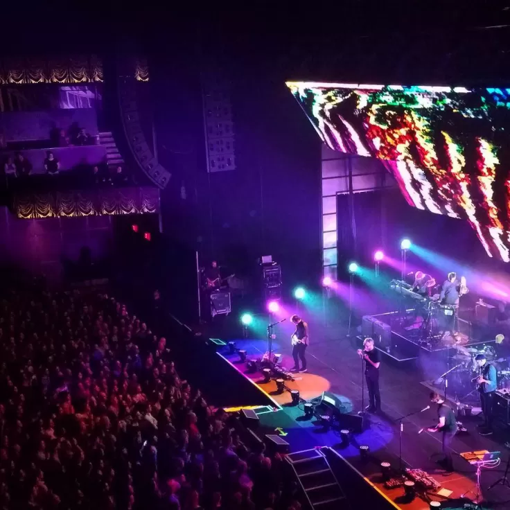 A concert full of fans and bright lights on the stage at The Anthem