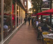 The exterior of Jaleo by José Andrés in Washington, DC, with large red neon lettering and outdoor seating under red umbrellas.
