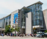 The exterior of the Walter E. Washington Convention Center on a bright day with crowds walking along the street.