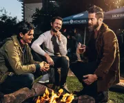 Friends gather around a fire.