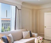 An elegant hotel room with a view of the Washington Monument. 