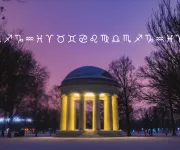 A photo of the DC War Memorial glowing against a purple night sky with icons of each zodiac sign incorporated into the background.