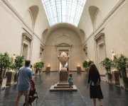 People walk down a grand hallway at the National Gallery of Art.