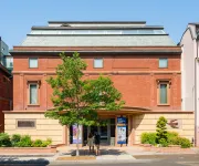 The Phillips Collection, a red-brick building with blue awnings and a street tree on a sunny day