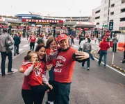 Familia tomando selfie en frente del Nationals Park antes del partido de béisbol de los Washington Nationals en Washington, DC