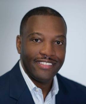 ray bennett, a black hotel executive, smiles in his professional headshot