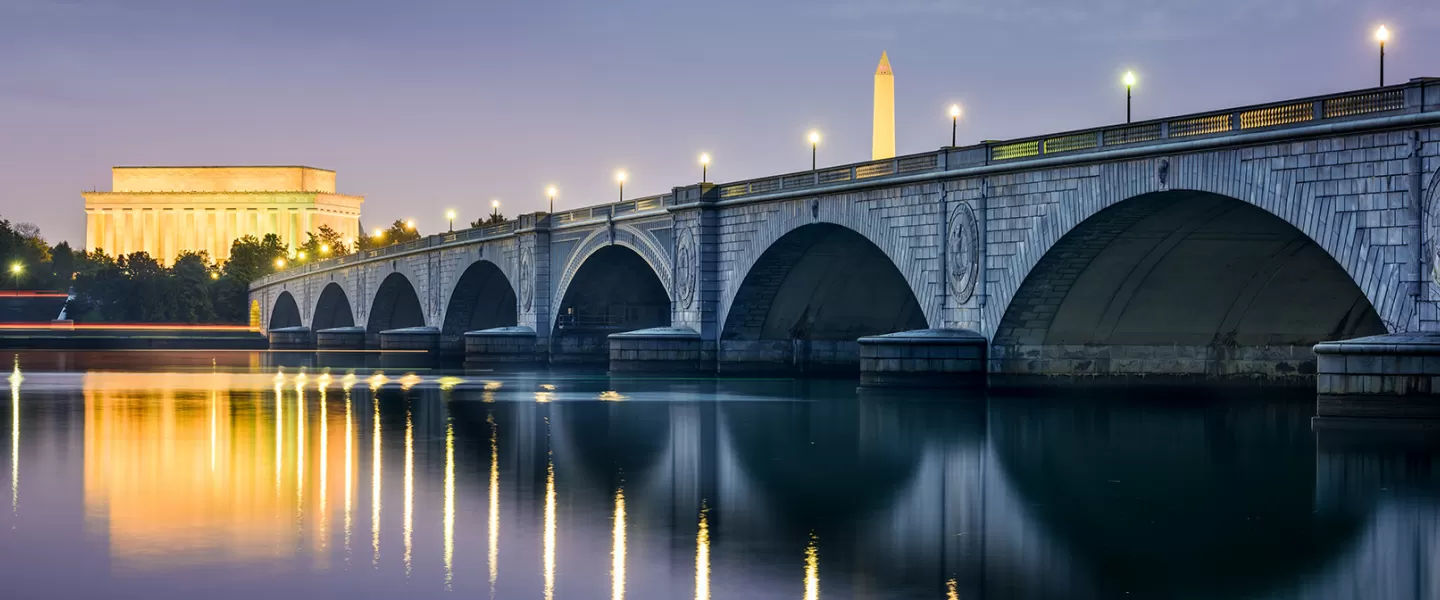 Nachts beleuchtete Arlington Bridge mit der Skyline von DC mit dem Lincoln Memorial und dem Washington Monument